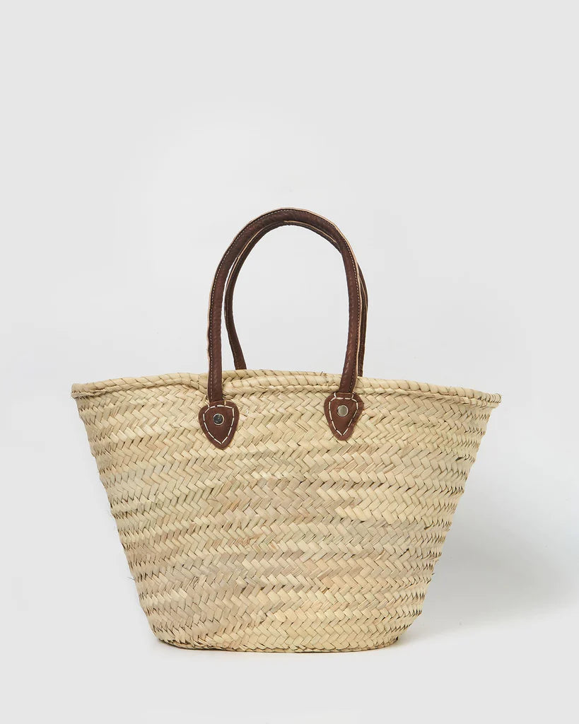 Handwoven Moroccan straw beach bag featuring a blue evil eye design with genuine leather handles.